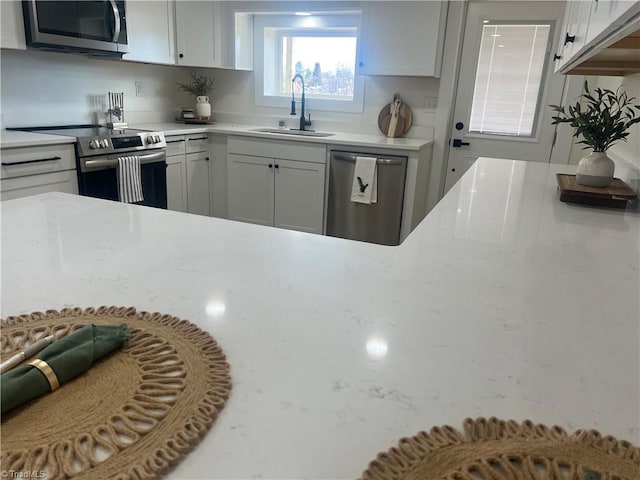 kitchen featuring appliances with stainless steel finishes, sink, and white cabinets