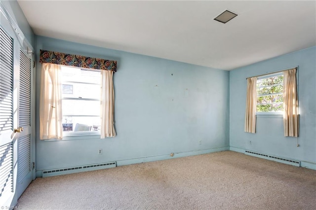 carpeted spare room featuring a baseboard radiator