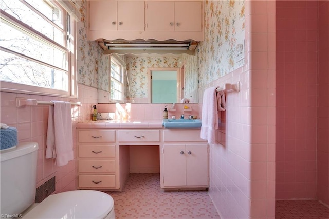 bathroom with tile flooring, tile walls, tasteful backsplash, and toilet