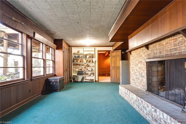 miscellaneous room with crown molding, a fireplace, carpet, and wood walls