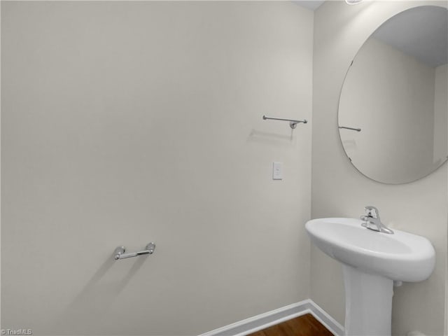 bathroom with wood finished floors and baseboards