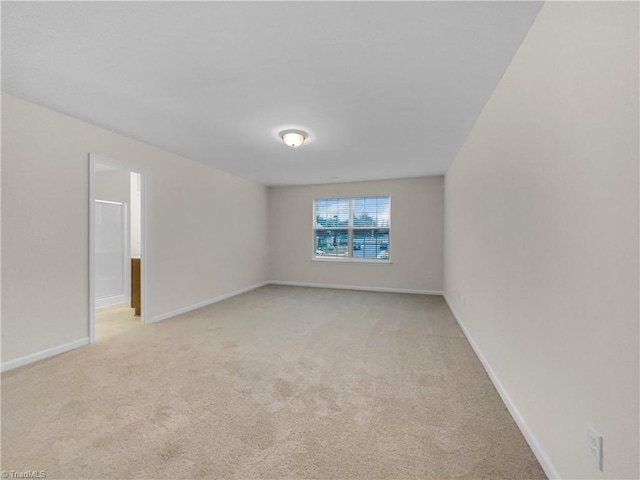 empty room with light colored carpet and baseboards