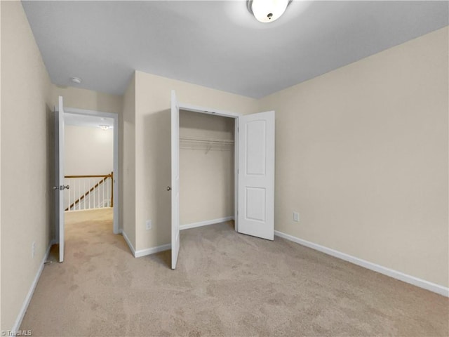 unfurnished bedroom featuring a closet, baseboards, and carpet floors