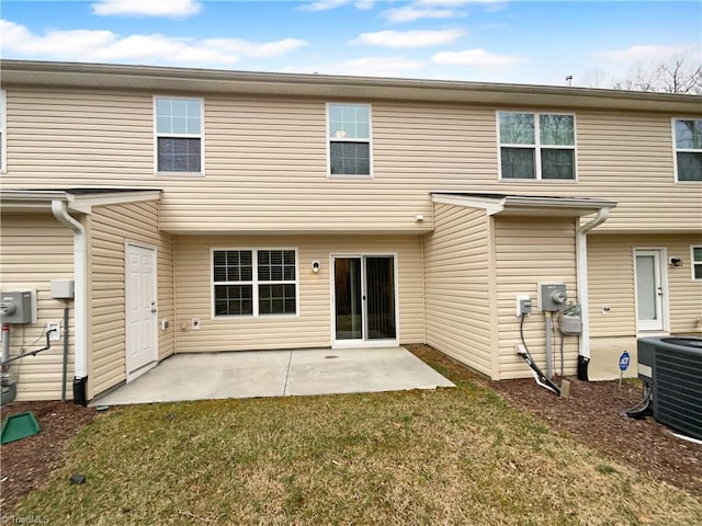 back of property with central AC unit, a lawn, and a patio