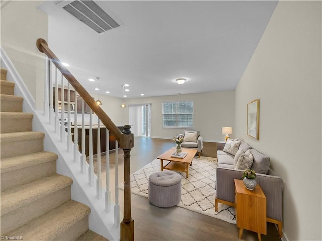 living room featuring stairway, recessed lighting, wood finished floors, and visible vents