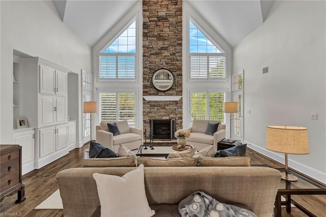living area with a stone fireplace, dark wood-style flooring, and high vaulted ceiling
