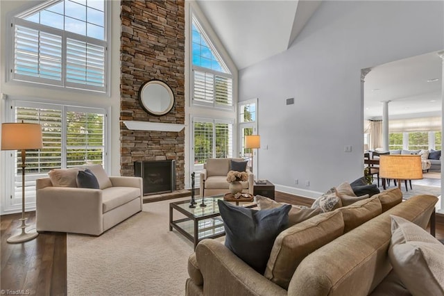 living area featuring a healthy amount of sunlight, high vaulted ceiling, and hardwood / wood-style floors