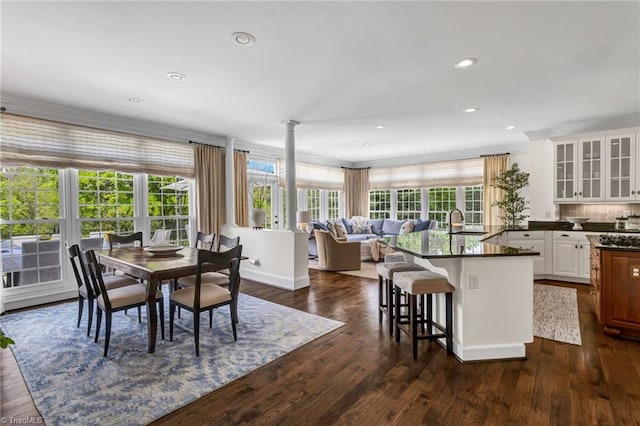 dining area featuring recessed lighting, dark wood-style flooring, and ornate columns