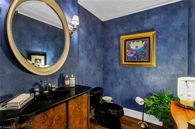 bathroom with wood finished floors, baseboards, vanity, toilet, and ornamental molding