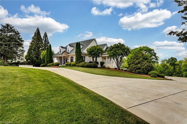 view of front facade featuring curved driveway and a front yard