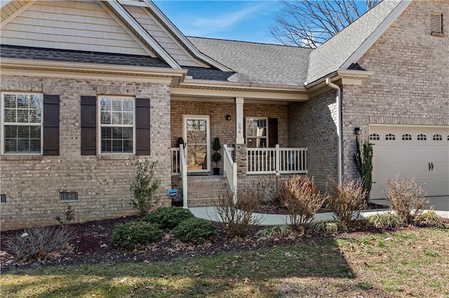 view of front of house with covered porch, a garage, brick siding, crawl space, and roof with shingles