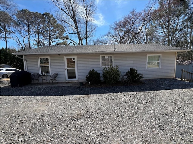 view of front of home featuring a shingled roof and a patio area