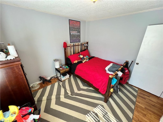 bedroom with a textured ceiling and wood finished floors