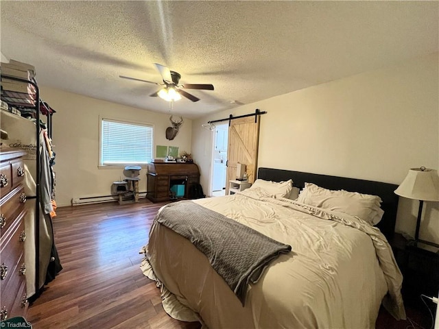 bedroom featuring ceiling fan, a textured ceiling, a barn door, a baseboard radiator, and dark wood-type flooring