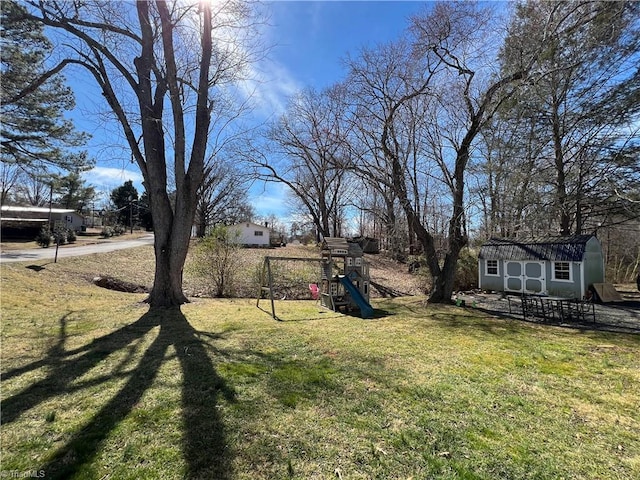 view of yard with an outbuilding, a playground, and a shed