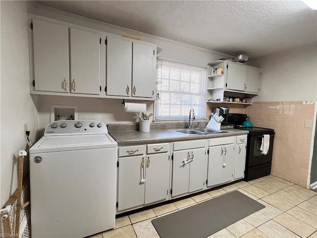 kitchen featuring light tile patterned floors, washer / clothes dryer, a sink, a textured ceiling, and black range with electric cooktop