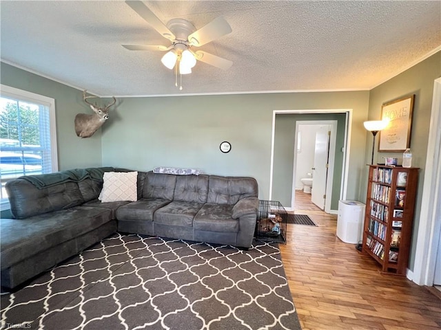 living room featuring a textured ceiling, stairs, a ceiling fan, and wood finished floors