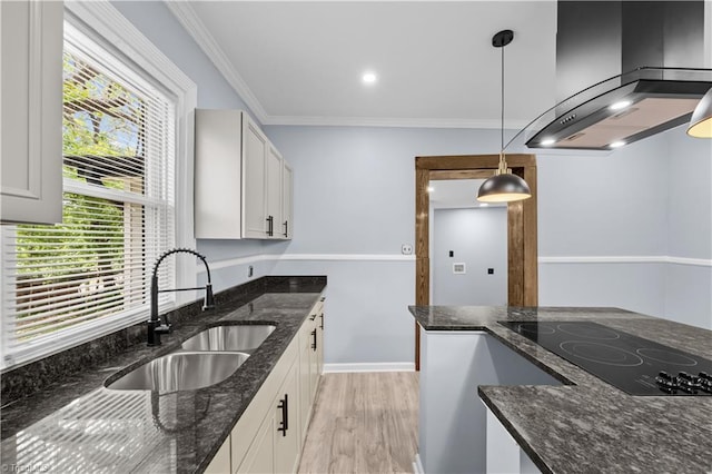 308 Worrell St, Thomasville, NC 27360 - kitchen with wall chimney range hood, black electric stovetop, light wood-type flooring, ornamental molding, and pendant lighting
