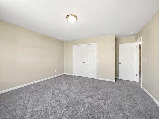 unfurnished bedroom with a closet and dark colored carpet