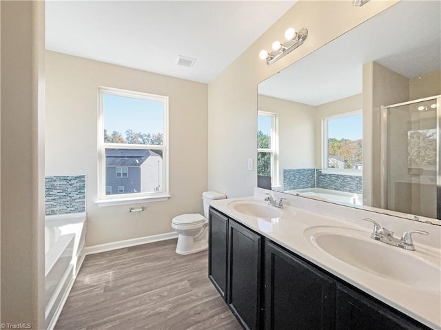 full bathroom featuring toilet, vanity, plus walk in shower, and wood-type flooring