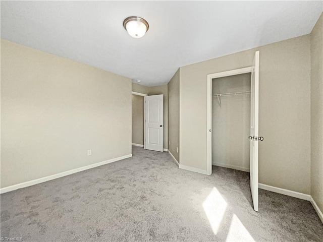 unfurnished bedroom featuring a closet and light colored carpet