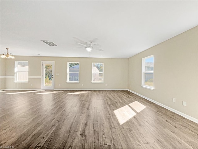 unfurnished room with light hardwood / wood-style flooring and ceiling fan with notable chandelier