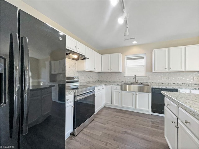 kitchen featuring sink, black appliances, white cabinets, and light hardwood / wood-style flooring