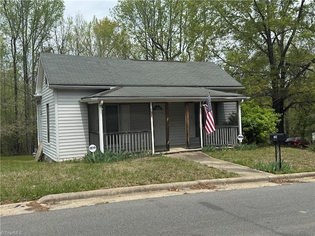 view of front of home featuring a porch, roof with shingles, and a front lawn