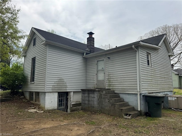 back of property featuring a chimney and entry steps