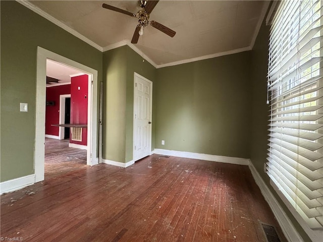unfurnished room with baseboards, crown molding, ceiling fan, and wood finished floors