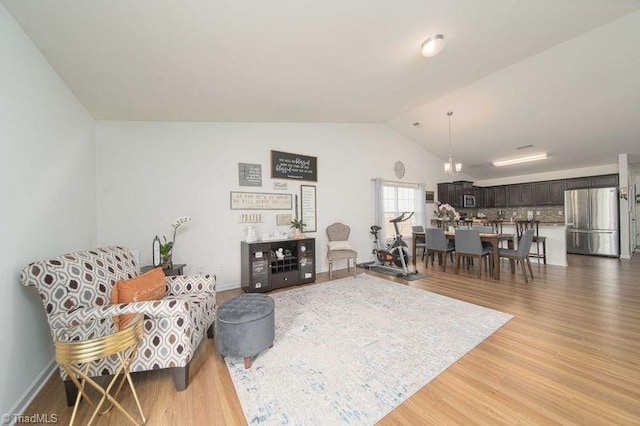 living room featuring vaulted ceiling and light wood finished floors