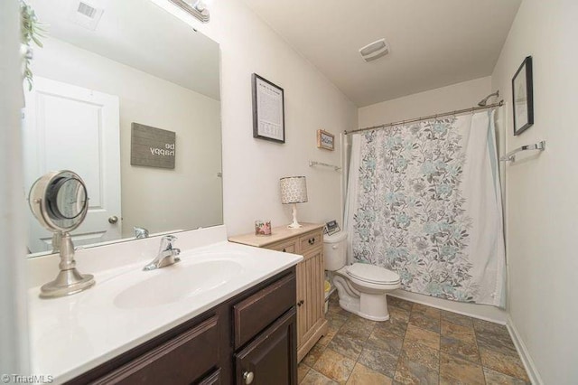 full bath featuring stone finish floors, toilet, vanity, and a shower with shower curtain