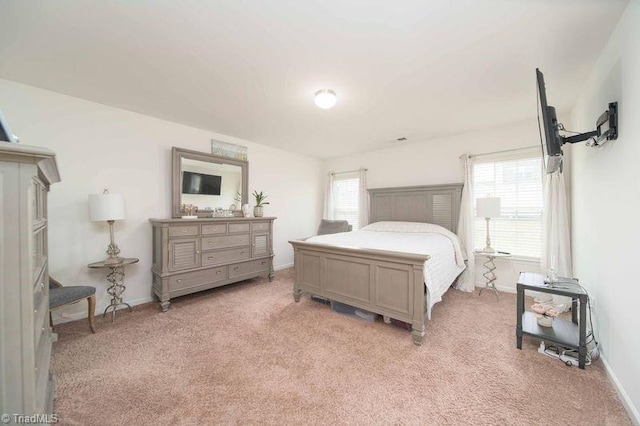 bedroom with light carpet and baseboards