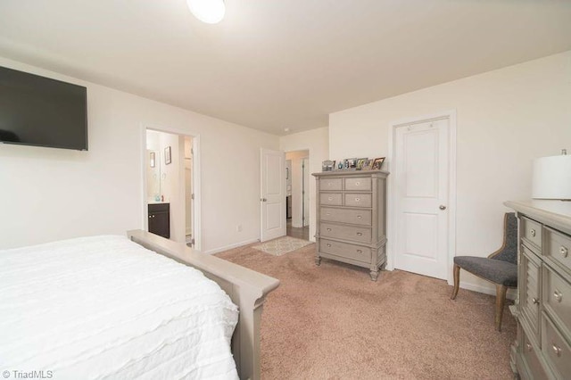 bedroom with light carpet, connected bathroom, and baseboards