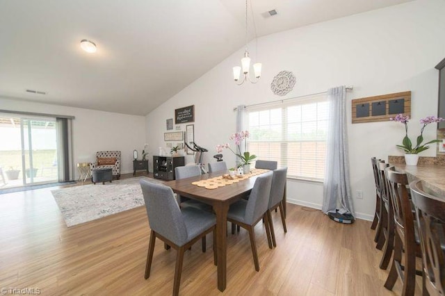 dining room featuring a chandelier, light wood-type flooring, baseboards, and high vaulted ceiling