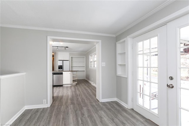 interior space featuring built in shelves, wood-type flooring, and ornamental molding