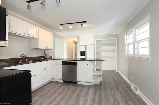 kitchen featuring kitchen peninsula, stainless steel dishwasher, sink, white refrigerator with ice dispenser, and white cabinets