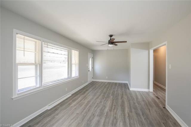 unfurnished room with ceiling fan, a baseboard heating unit, and hardwood / wood-style flooring