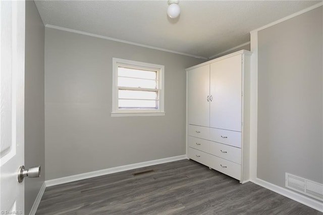 unfurnished bedroom with dark wood-type flooring and ornamental molding