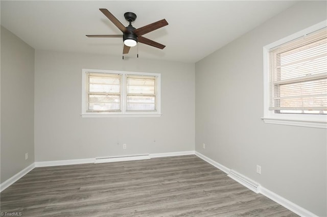 unfurnished room featuring plenty of natural light, ceiling fan, wood-type flooring, and a baseboard radiator