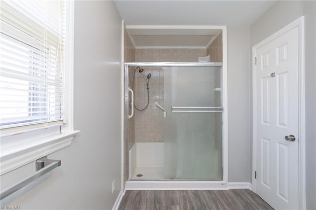 bathroom with hardwood / wood-style floors and a shower with door