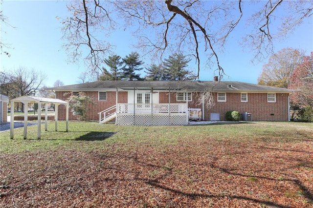 rear view of property featuring french doors, central AC unit, and a lawn