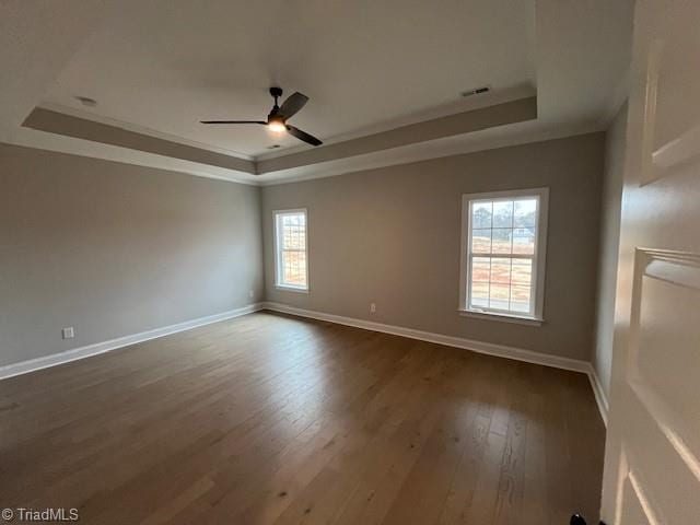 unfurnished room featuring hardwood / wood-style floors, ornamental molding, a raised ceiling, and ceiling fan