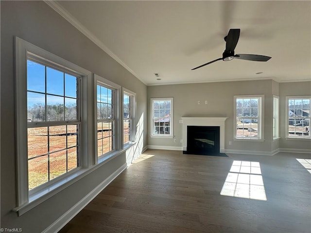 unfurnished living room featuring dark wood-type flooring, baseboards, ornamental molding, and ceiling fan