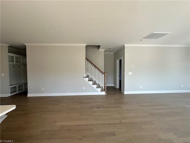 unfurnished living room featuring stairway, visible vents, baseboards, and ornamental molding