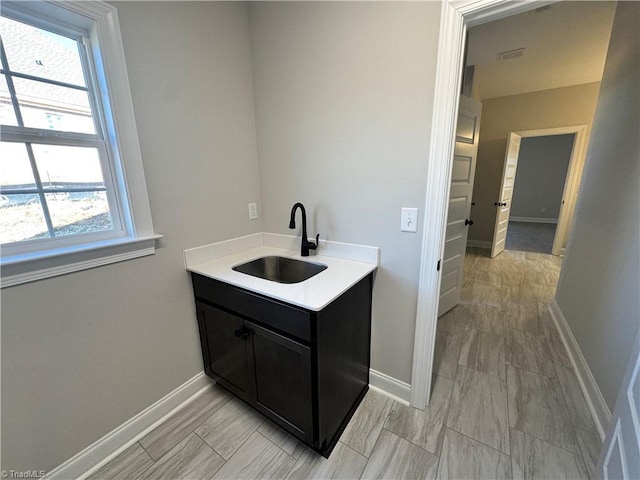interior space with visible vents, a sink, and baseboards