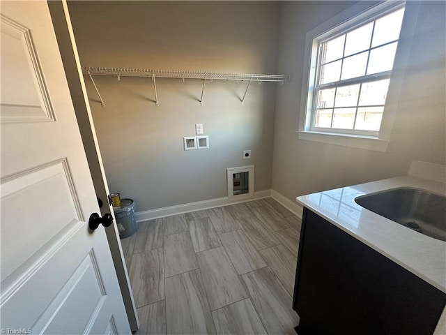 clothes washing area with laundry area, electric dryer hookup, washer hookup, a sink, and baseboards
