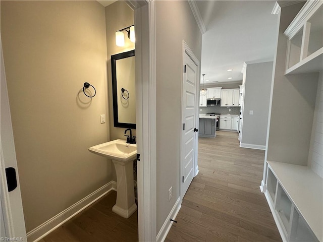 bathroom with ornamental molding, baseboards, recessed lighting, and wood finished floors