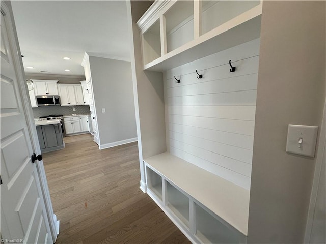 mudroom featuring ornamental molding, baseboards, light wood-type flooring, and recessed lighting