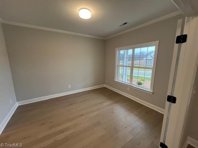 unfurnished room featuring ornamental molding and hardwood / wood-style floors